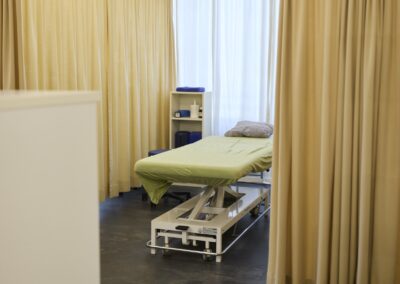 Gelb gestaltete Behandlungskabine mit Behandlungsliege