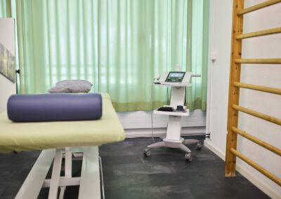 Grün gestaltete Behandlungskabine mit Behandlungsliege