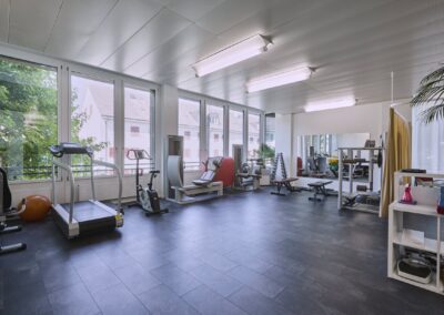 Trainingsraum mit grossen Fenstern und Trainingsgeräten